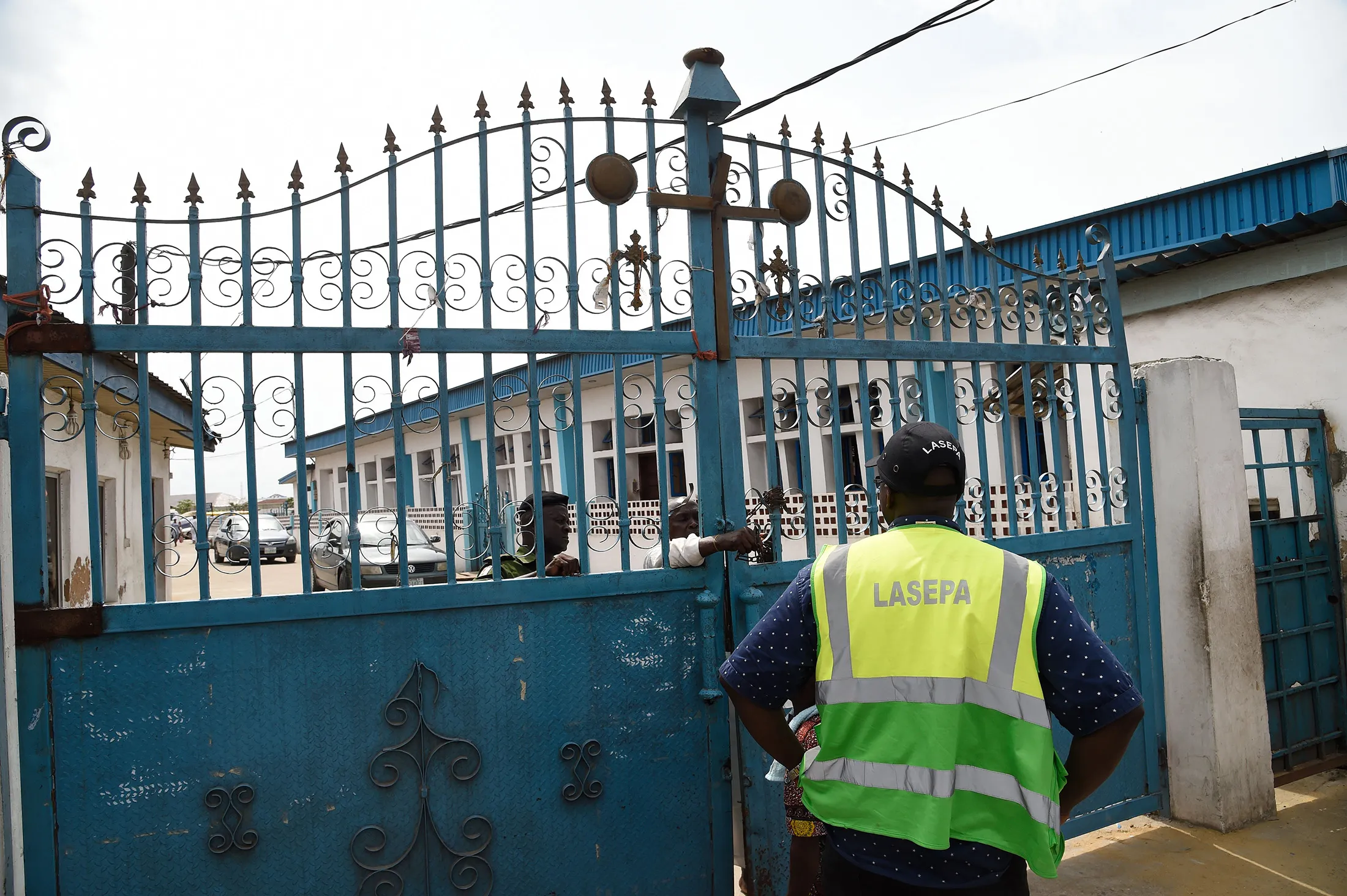 A member of the Task Force stands as the main gate to a church is being opened for inspection to enforce the government directive against social gatherings in Lagos on March 22.