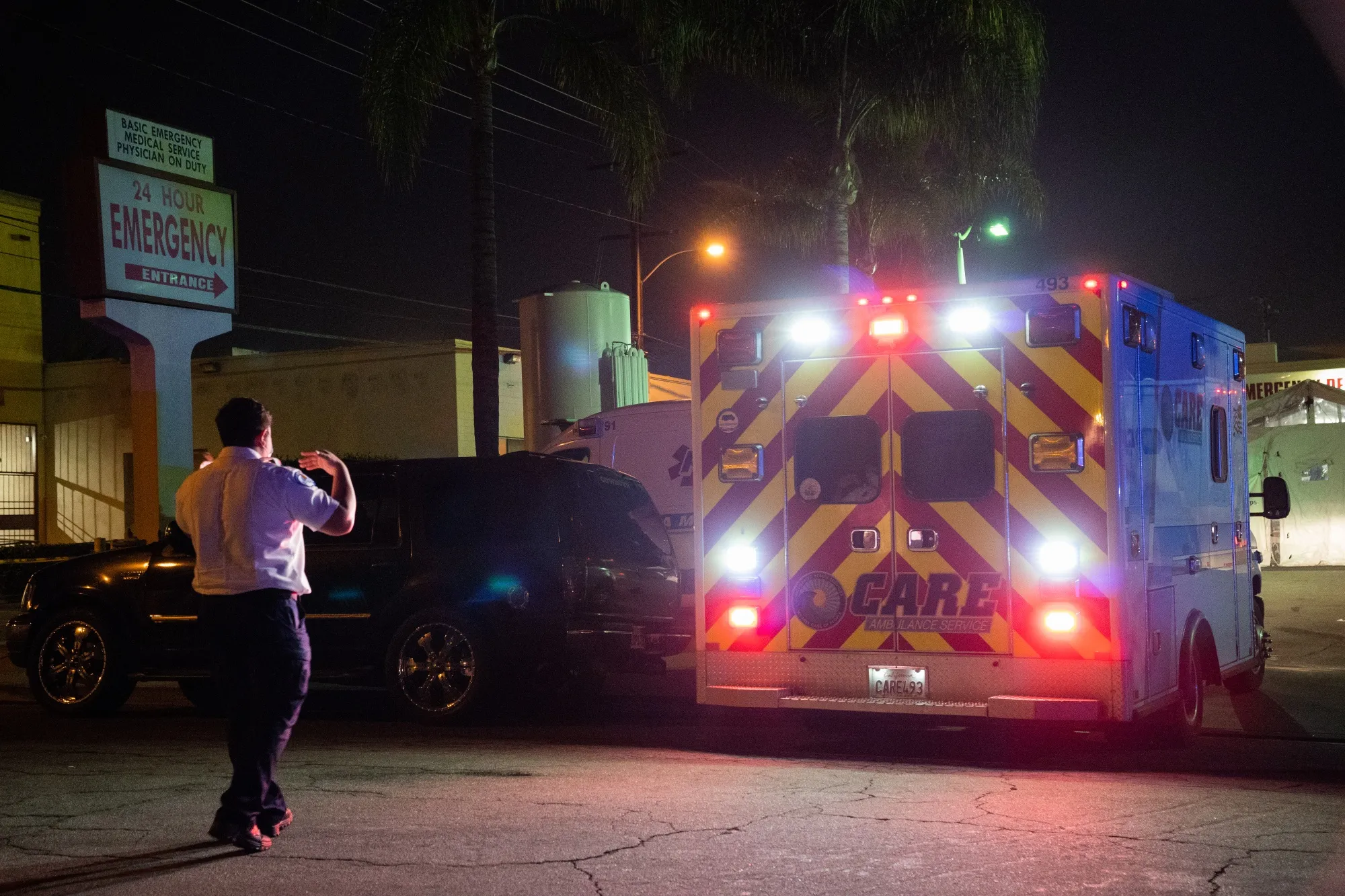 An emergency medical technician directs an ambulance outside the emergency room of the East Los Angeles Doctors Hospital in Los Angeles, California.