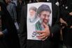A man holds a poster of Iran’s Supreme Leader Mojtaba Khamenei, right, and the late Ayatollah Ali Khamenei, in Tehran, on March 11.