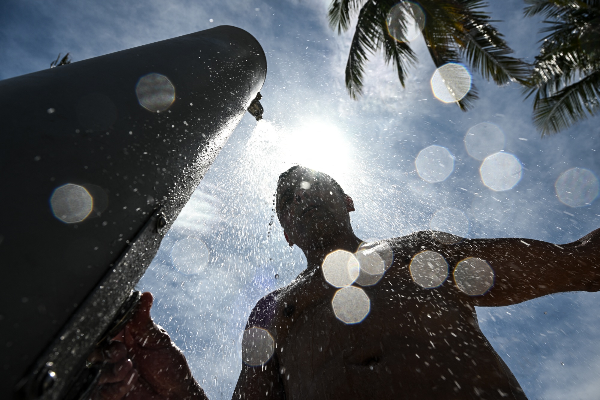 A man takes a shower during a hot afternoon in Miami Beach, Florida, in July 2025. 