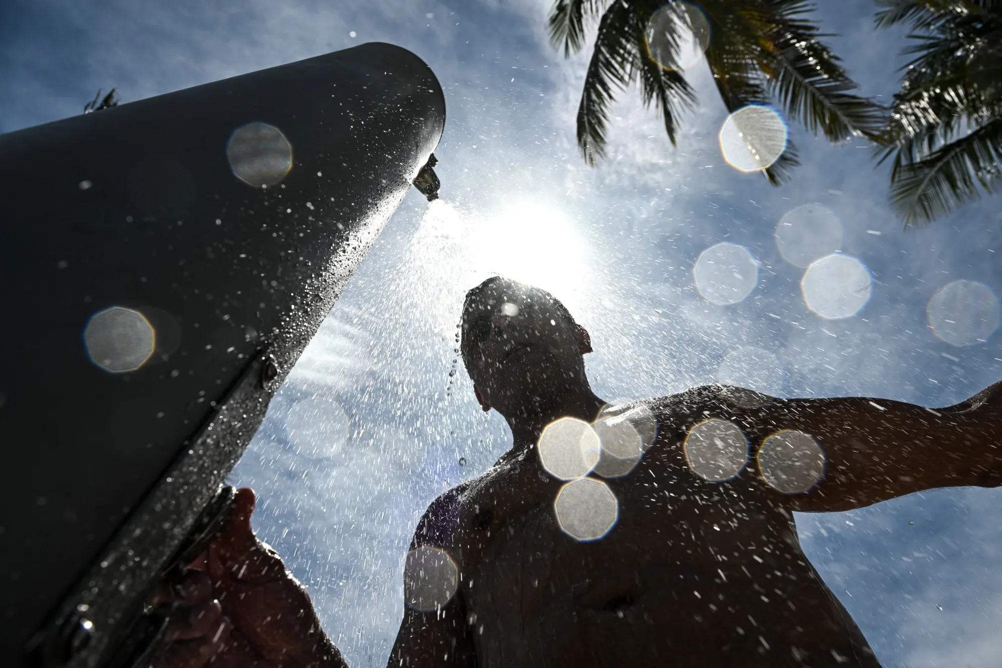 A man takes a shower during a hot afternoon in Miami Beach, Florida, in July 2025.&nbsp;