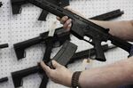 A salesperson holds a high capacity magazine for an AR-15 rifle at a firearms store in Orem, Utah.