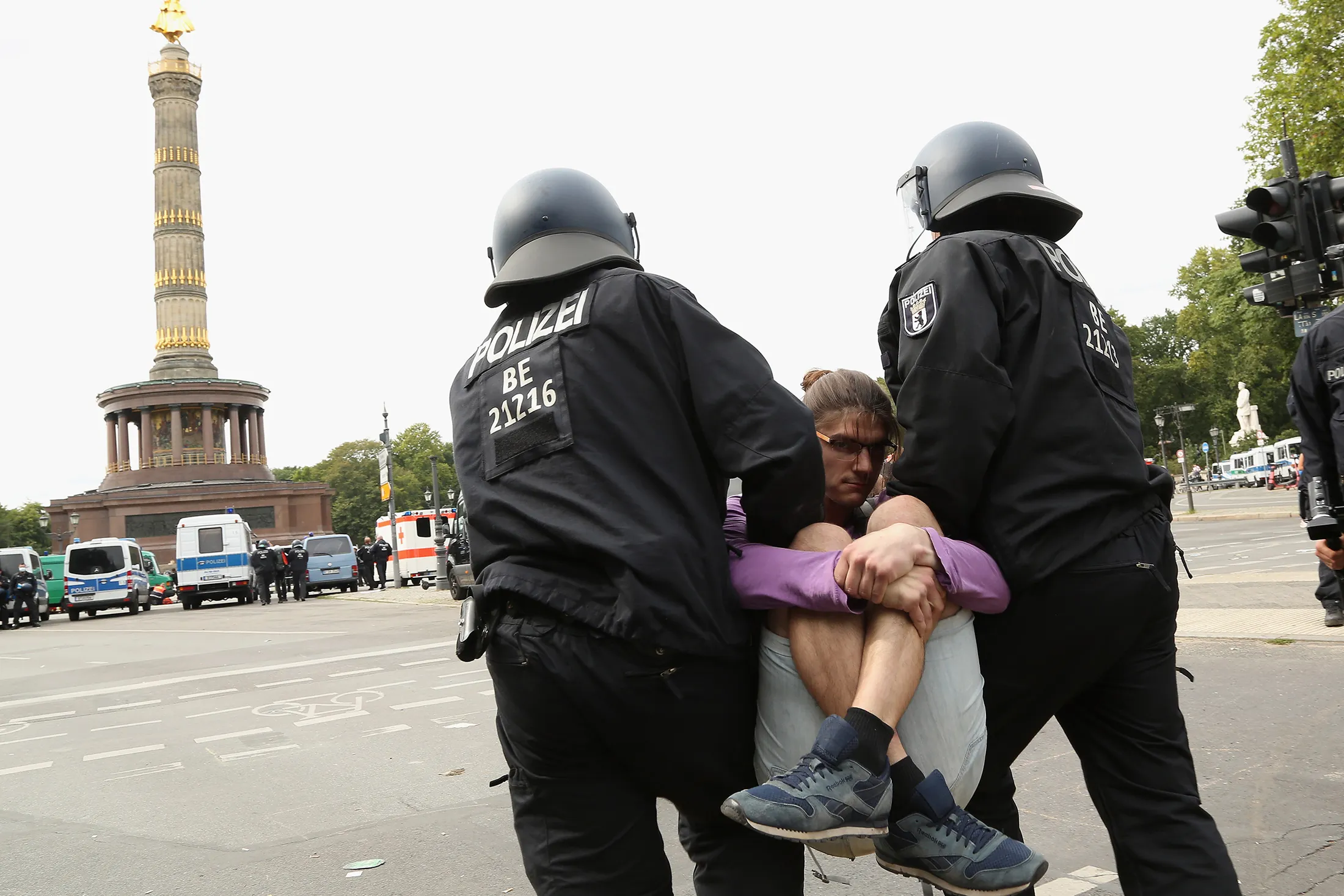 Police officers carry away a protester at an unregistered demonstration against government coronavirus regulations held next to the Siegesaeule in Berlin, on Aug. 30.