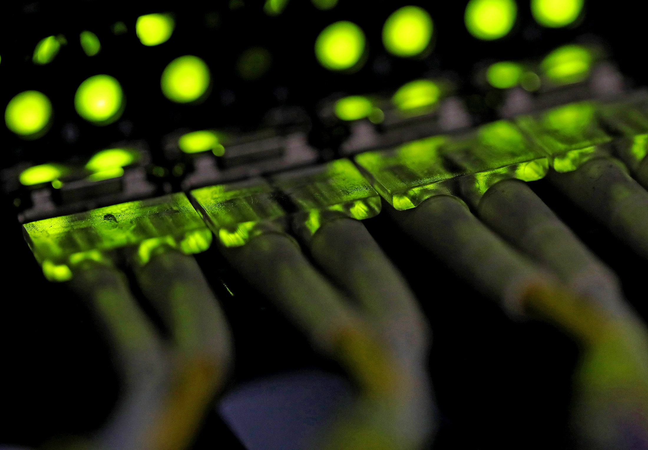 Green light illuminates data cable terminals inside a communications room at an office in London, U.K., on Monday, May 15, 2017. Governments and companies around the world began to gain the upper hand against the first wave of an unrivaled global cyberattack, even as the assault was poised to continue claiming victims this week.
