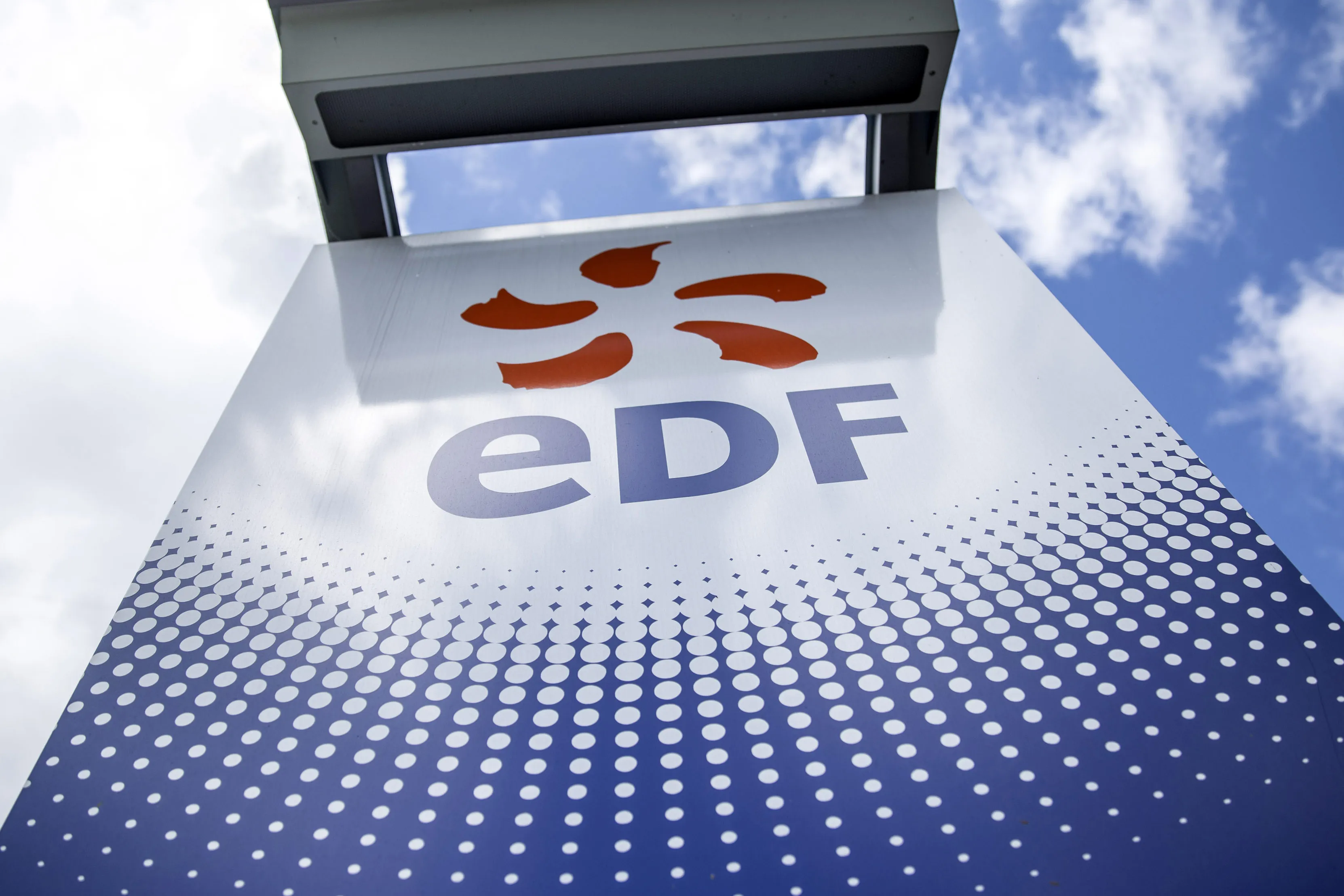 An EDF logo sits on a sign outside a hydroelectric power plant operated by Electricite de France SA (EDF), in Bort-les-Orgues, France, on Tuesday, May 13, 2014. President Francois Hollande has vowed to lower dependence on nuclear power to 50 percent of all electricity produced by around 2025.
