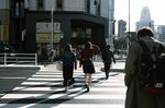 Pedestrians walk across a road in the Shinjuku district of Tokyo, Japan, on Thursday, Nov. 19, 2020.