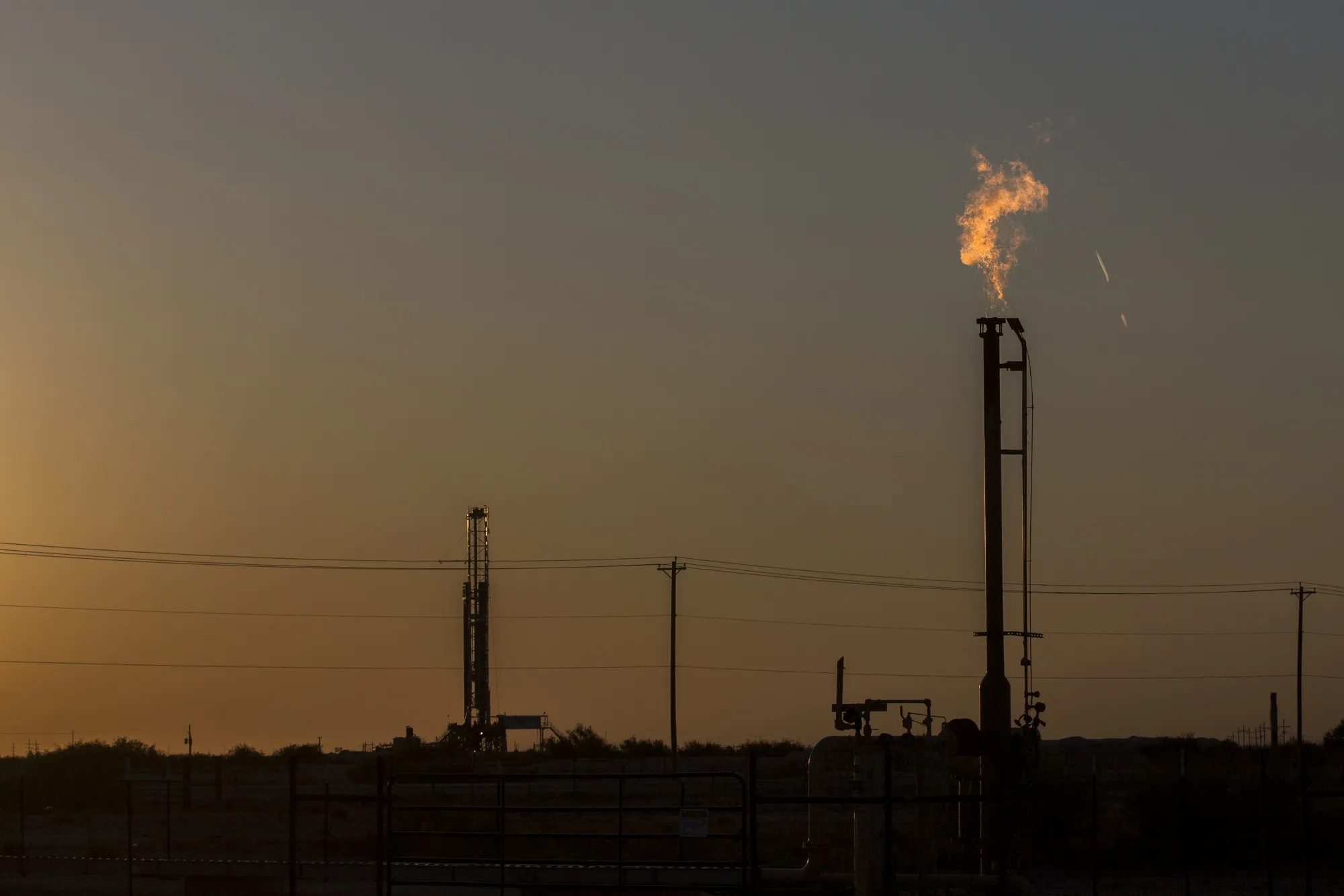 A gas flare burns at dusk in the Permian Basin in Texas, U.S.