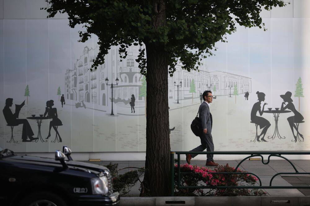 A morning commuter walks past a mural in the Marunouchi district in Tokyo.