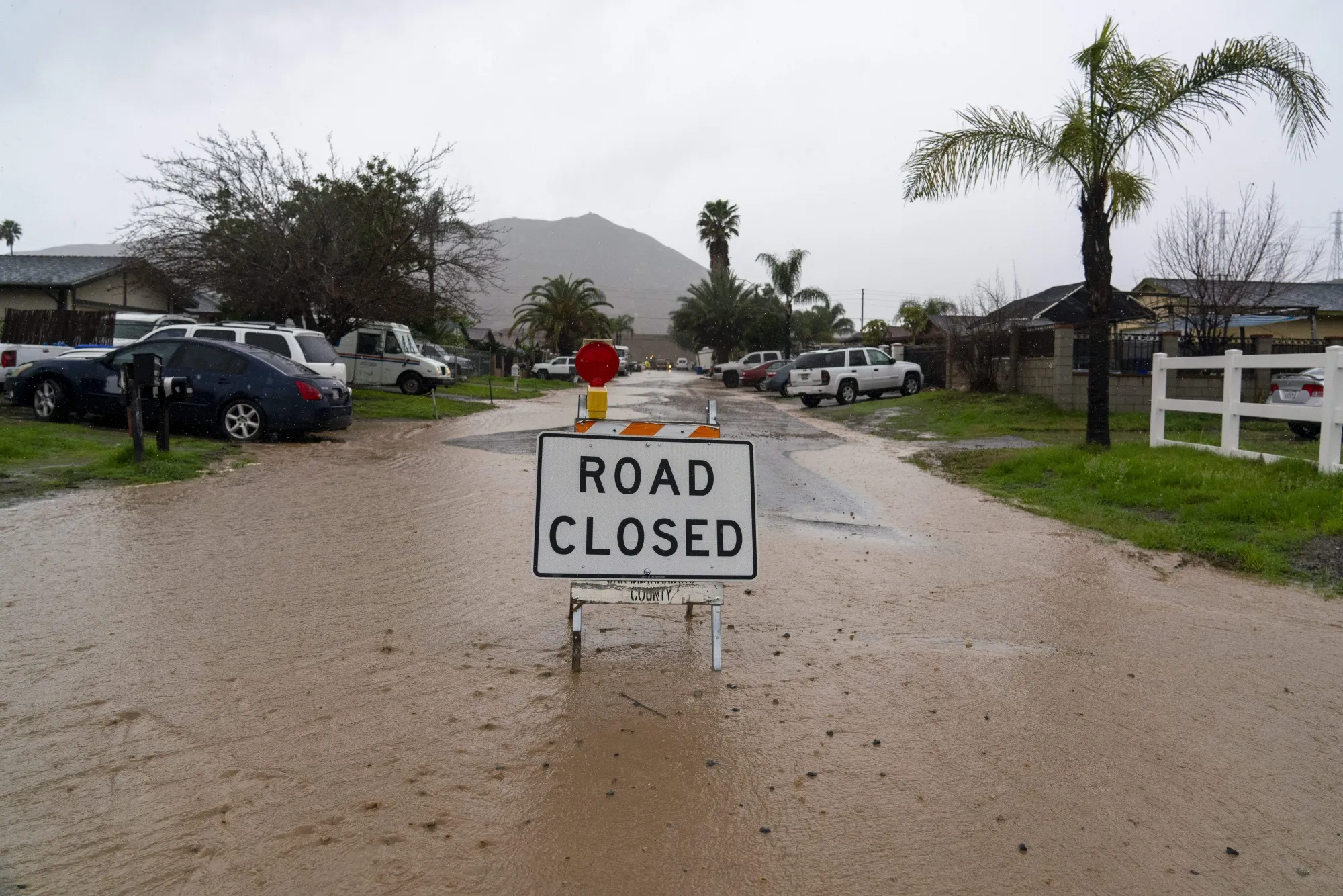 A road closure sign on a flooded road during a storm in Fontana, California.
