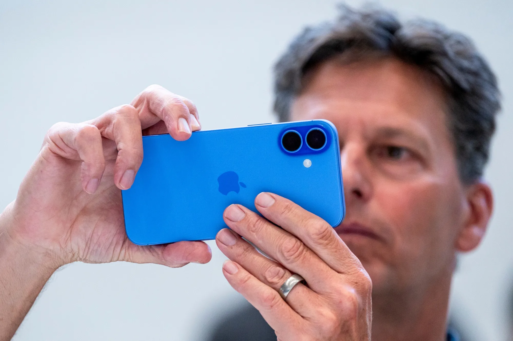A user taking a picture on the iPhone with the Camera Control button.