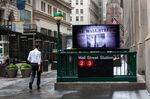 A pedestrian passes a Wall Street subway station near the New York Stock Exchange (NYSE) in New York.