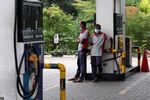 Gas station workers wait by a fuel pump after running out of gasoline in Kandy, Sri Lanka.
