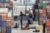 Trucks and forklifts operate as containers sit stacked at the Yangshan Deep Water Port in Shanghai, China, on Tuesday, July 10, 2018. China told companies to boost imports of goods from soybeans to seafood and automobiles from countries other than the U.S. after trade tensions between the world's two biggest economies escalated into a tariff war last week.
