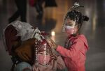 Children wear plastic bottles as makeshift homemade protection at Beijing Capital Airport on Jan. 30.