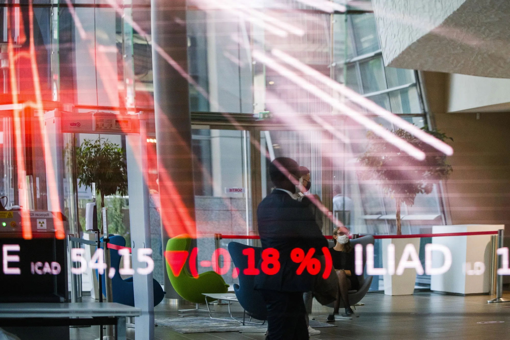 Downwards stock price information graphics are displayed in the lobby of the Euronext NV stock exchange in Paris.