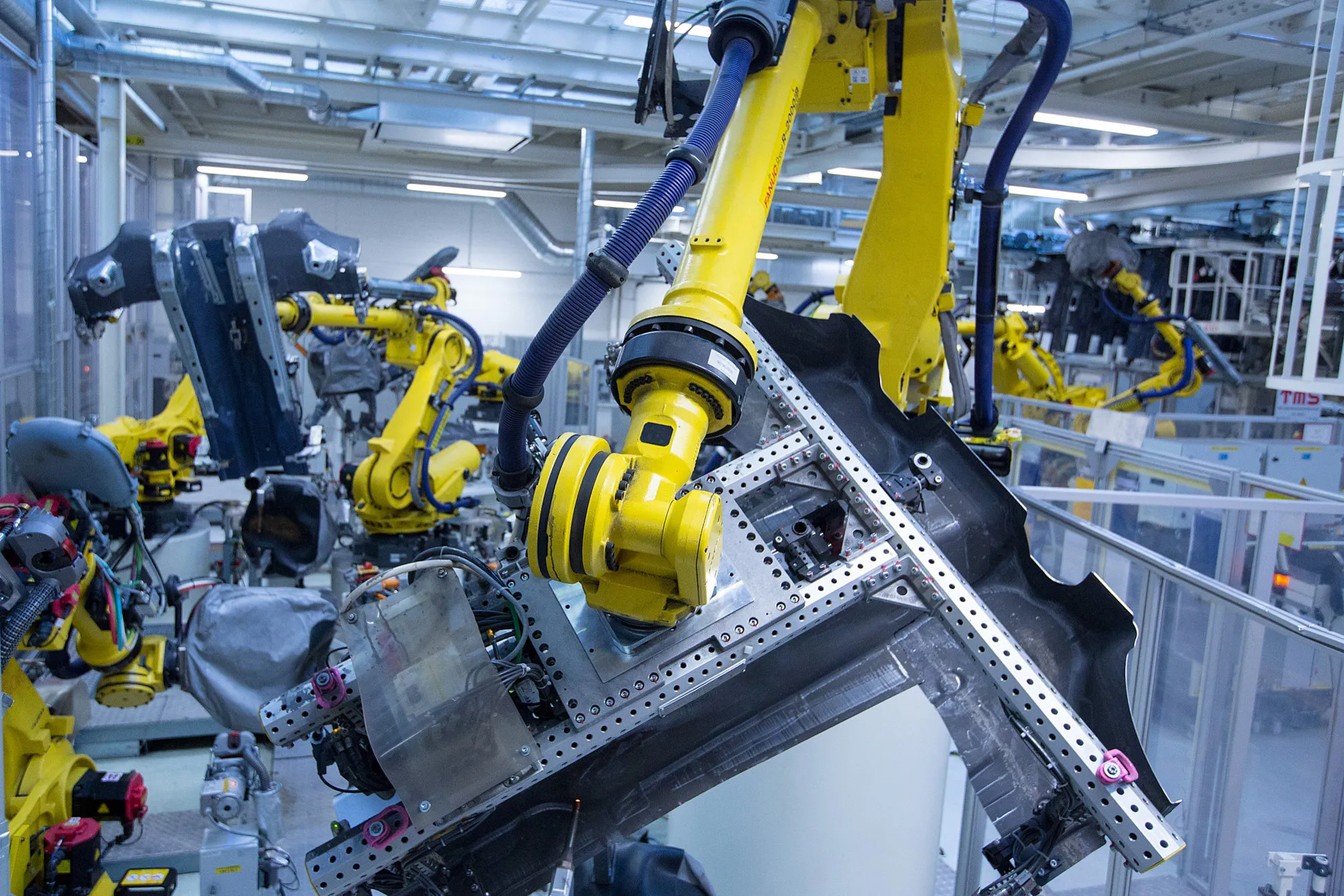 Robotic arms weld parts to be used in an automobile chassis in the Volkswagen AG factory, as part of the Think Blue sustainability initiative in Wolfsburg, Germany, on Friday, May 19, 2017. European car sales fell the most in four years in April as the shift of Easter from March reduced buyers time for shopping, while registrations in the U.K. were further sapped by tax changes.
