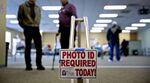A "Photo ID Required Today" sign hangs at the entrance of a polling location during the presidential primary vote in Waukesha, Wisconsin, in 2016. The spread of voter ID laws could disenfranchise transgender people, advocates say.&nbsp;
