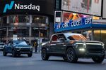 Rivian R1T electric pickup trucks drive through Times Square during the company's IPO outside the Nasdaq MarketSite in New York, U.S., on Wednesday, Nov. 10, 2021. Electric vehicle-maker Rivian Automotive Inc. priced shares in its initial public offering at $78 apiece to raise about $11.9 billion, the biggest first-time share sale this year.