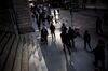 Pedestrians walk along Wall Street near the New York Stock Exchange (NYSE) in New York, U.S., on Monday, March 12, 2018. Stocks gave up early gains Monday as uncertainty over the prospect of tariffs undid some of the market's recent job-driven gains.