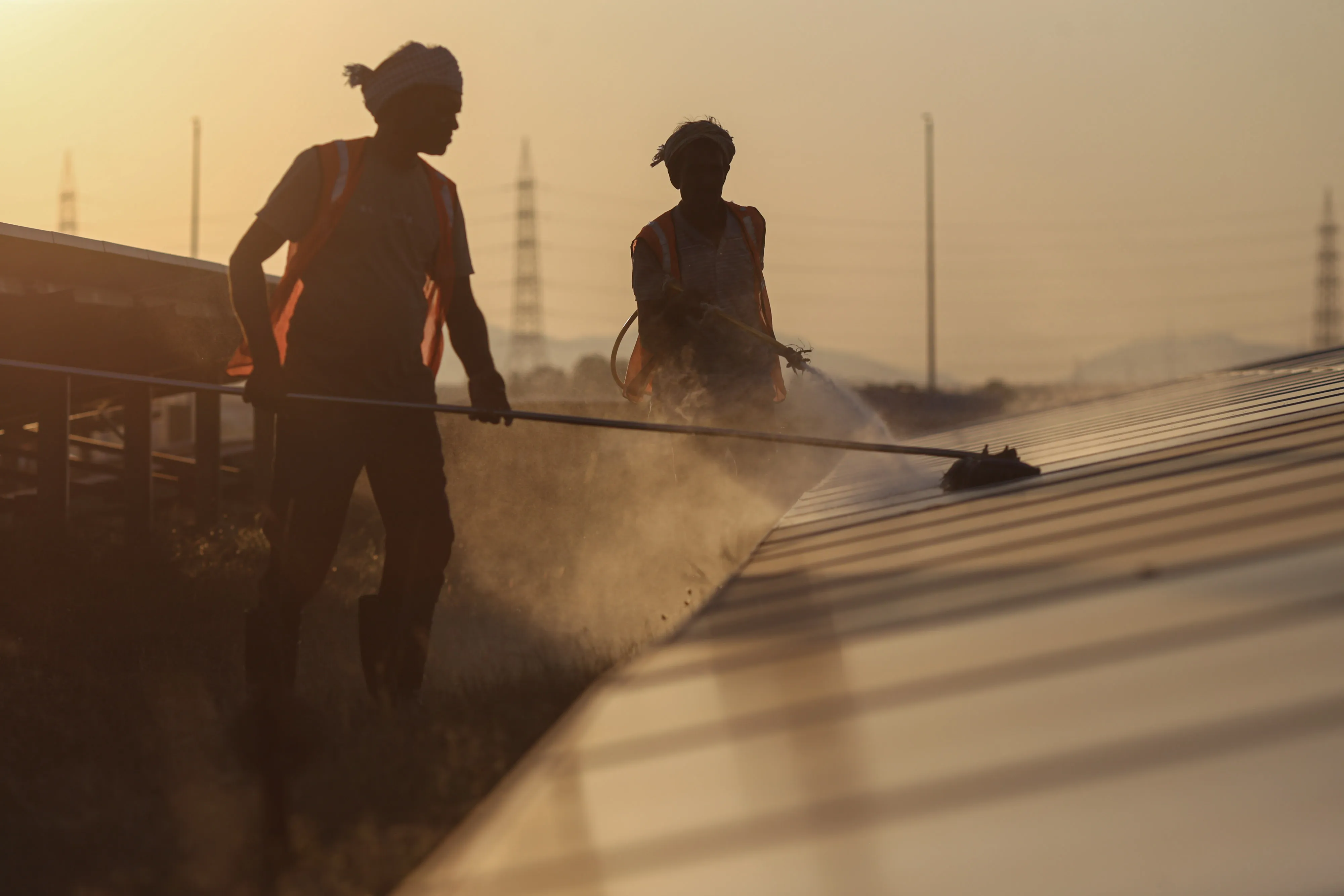 Workers wash photovoltaic panels at a solar farm in Karnataka state, India.
