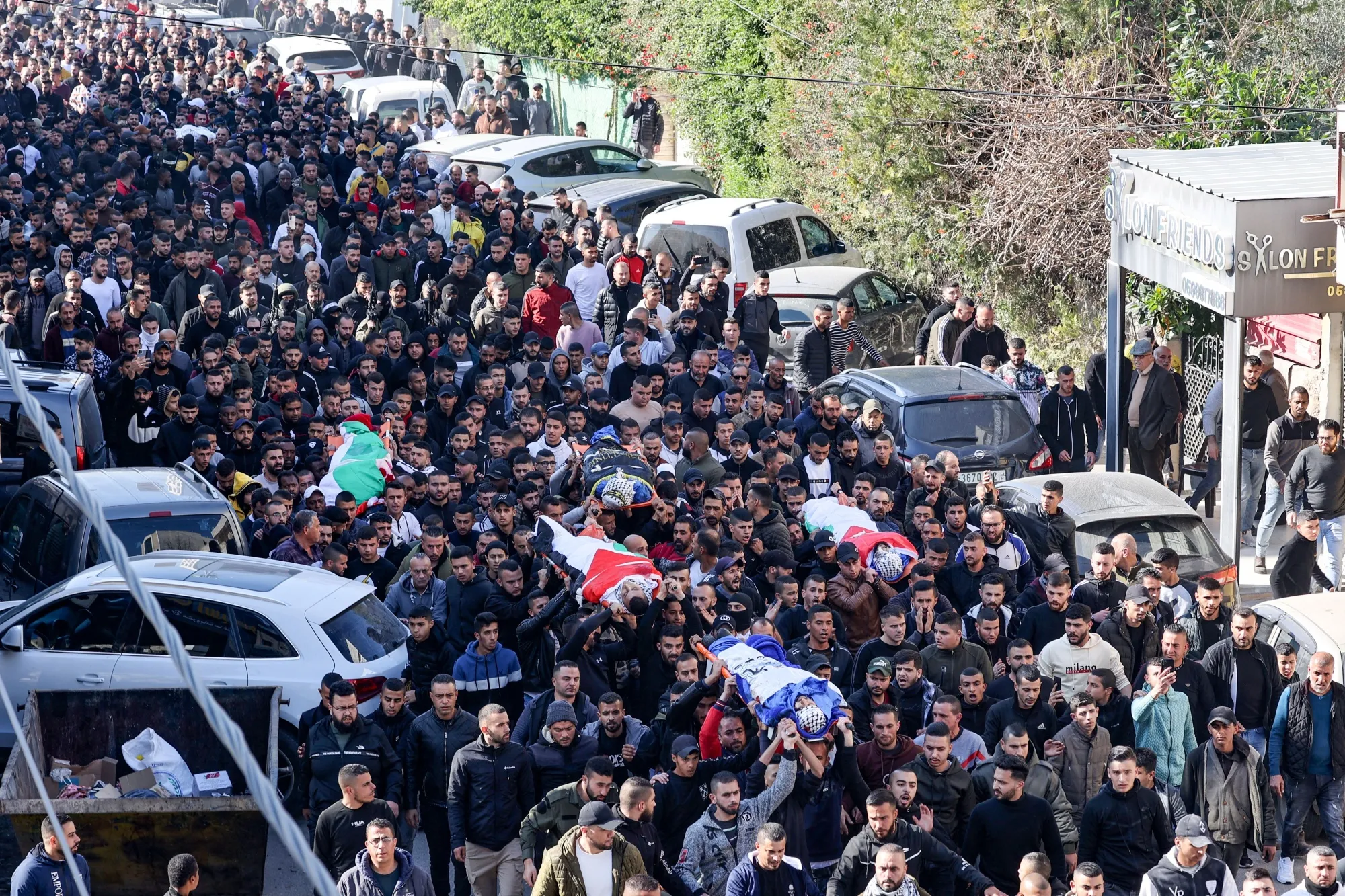 Palestinians carry the bodies of four of the 9 reported victims killed in the West Bank's Jenin refugee camp on January 26.&nbsp;