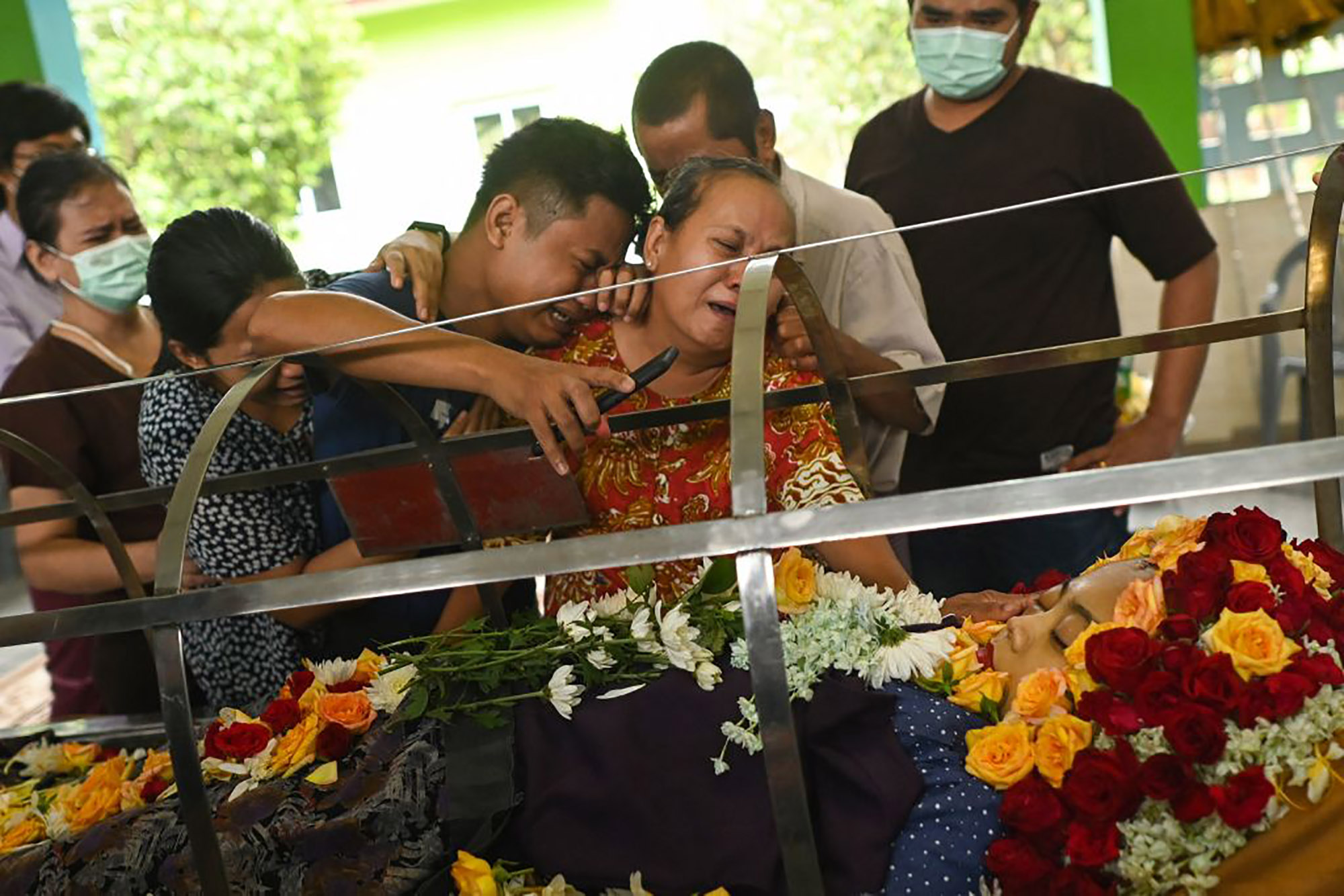 Relatives cry as they look at a body of a woman shot in her car on her way home from work, at Yayway cemetery in Yangon on April 2.&nbsp;