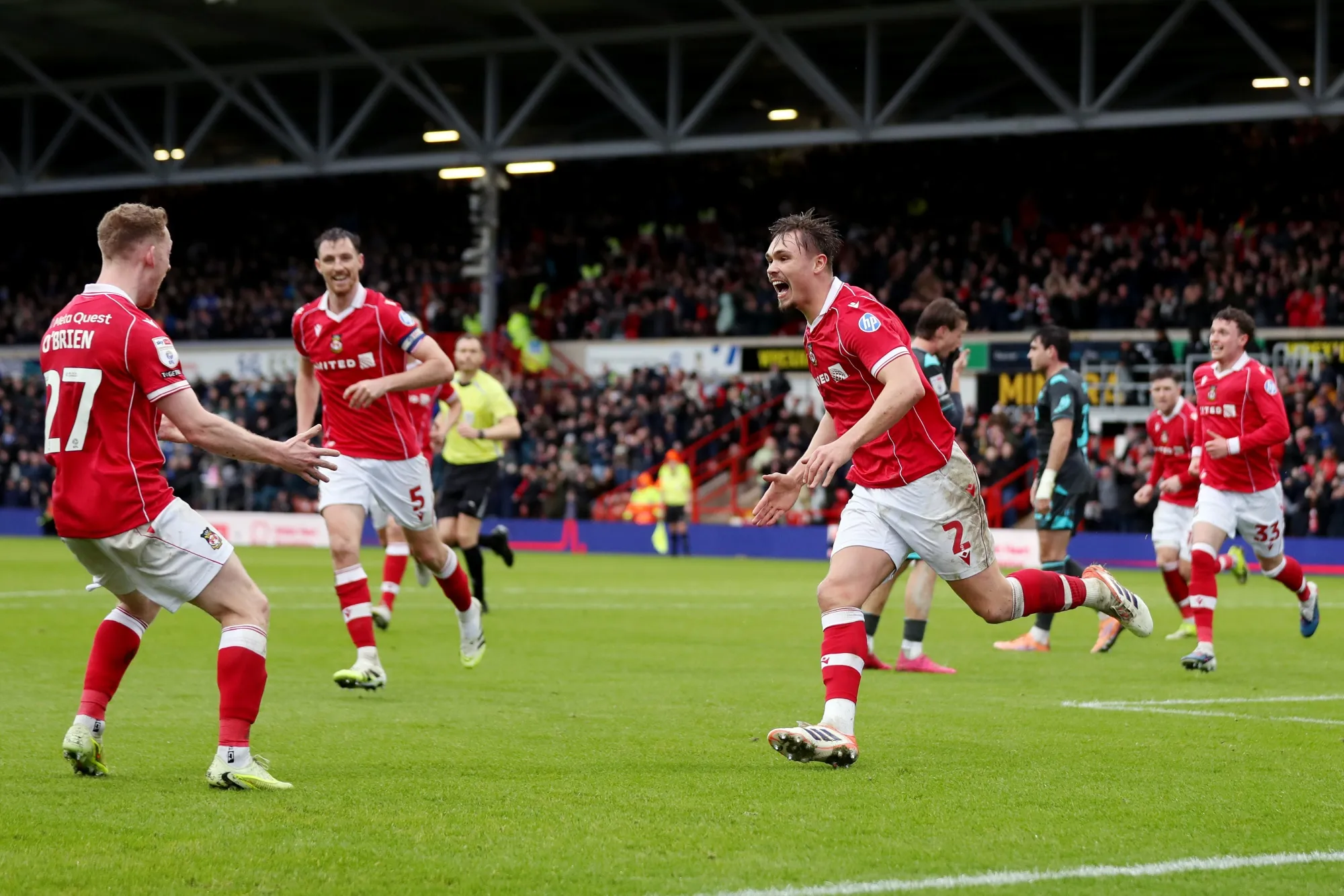 Callum Doyle, of Wrexham, celebrates scoring his team's fourth goal with teammate Lewis O'Brien during the Sky Bet Championship match in Wrexham, Wales, on Feb. 21.