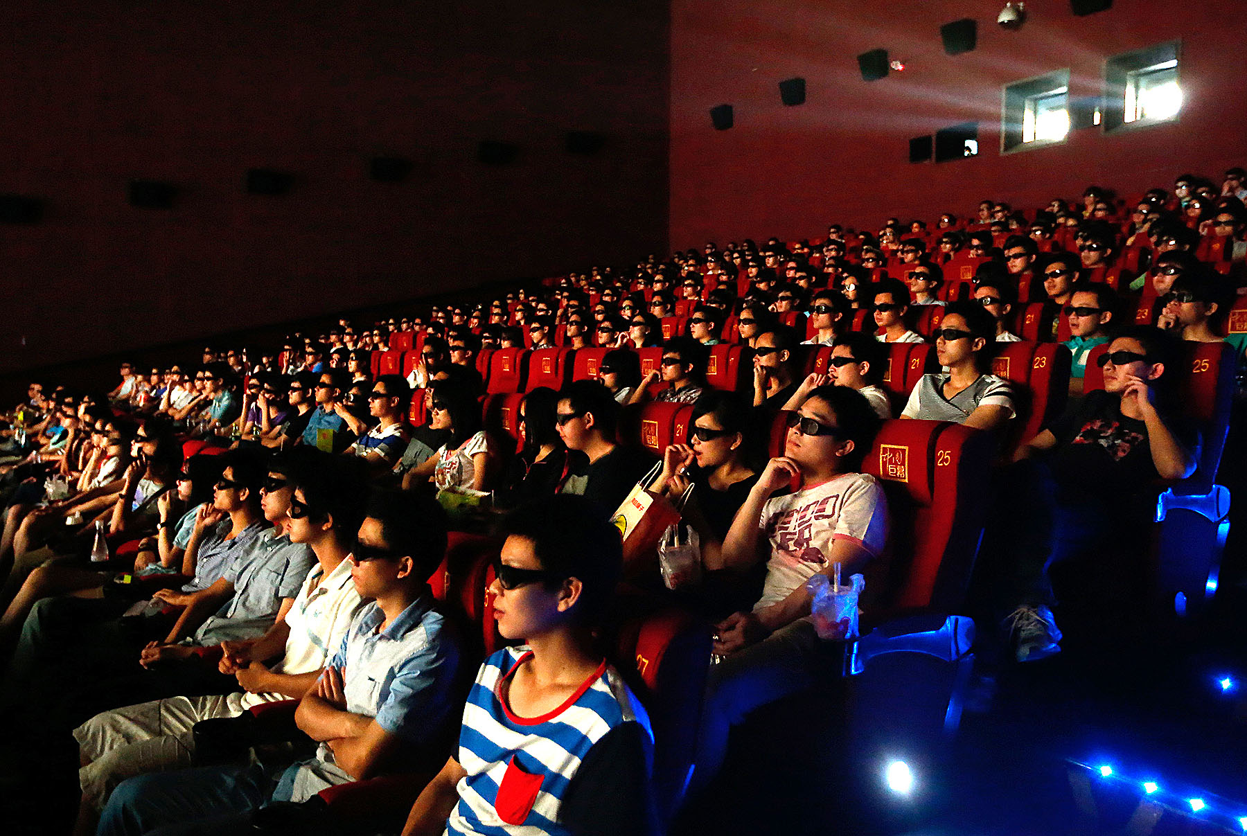 Audience watch the 3D film 'Transformers - Age Of Extinction' through 3D glasses at a cinema in Wuhan, China.
