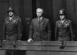 Friedrich Flick, flanked by U.S. Army guards in a courtroom at the Palace of Justice in Nuremberg, Germany, on Jan. 15, 1947.