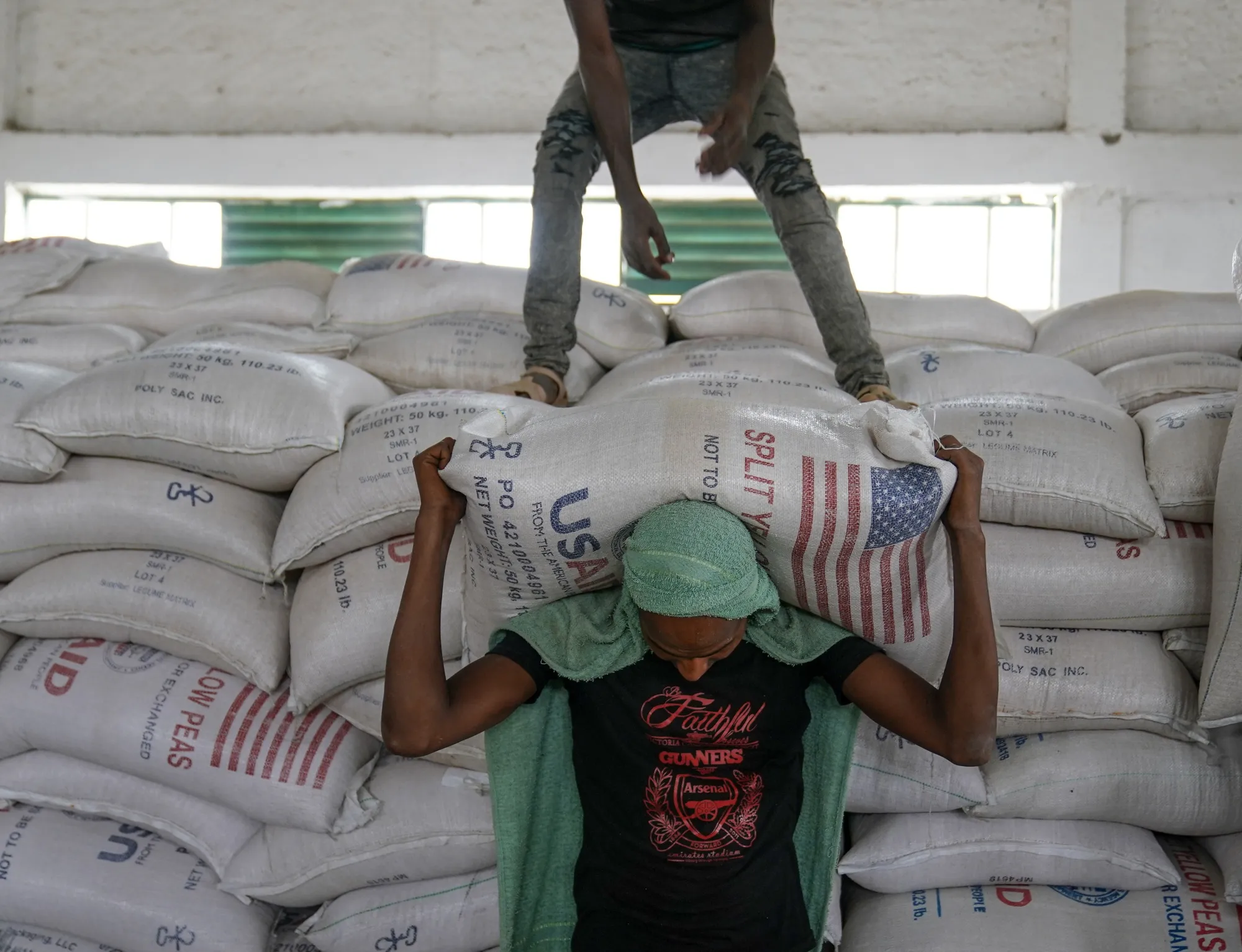Aid workers move bags of yellow lentils at an aid operation run by USAID, in Mekele, Ethiopia, in 2021.