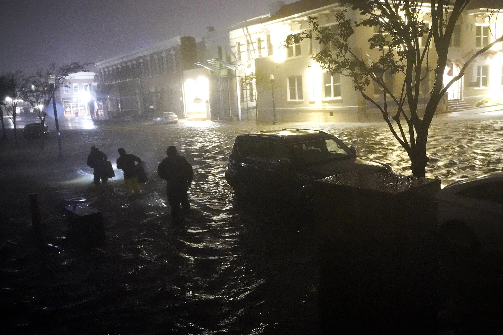 People struggle to cross flooded streets in Pensacola, Florida, on Sept. 16 as Hurricane Sally made landfall on the Gulf Coast.