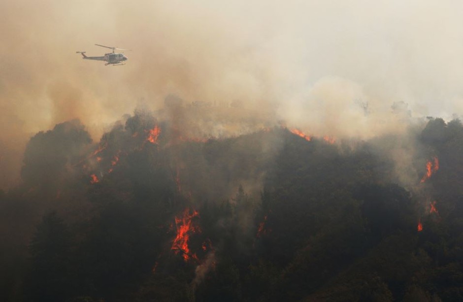 A firefighting helicopter flies over part of the Soberanes blaze in July near Carmel Valley, California.