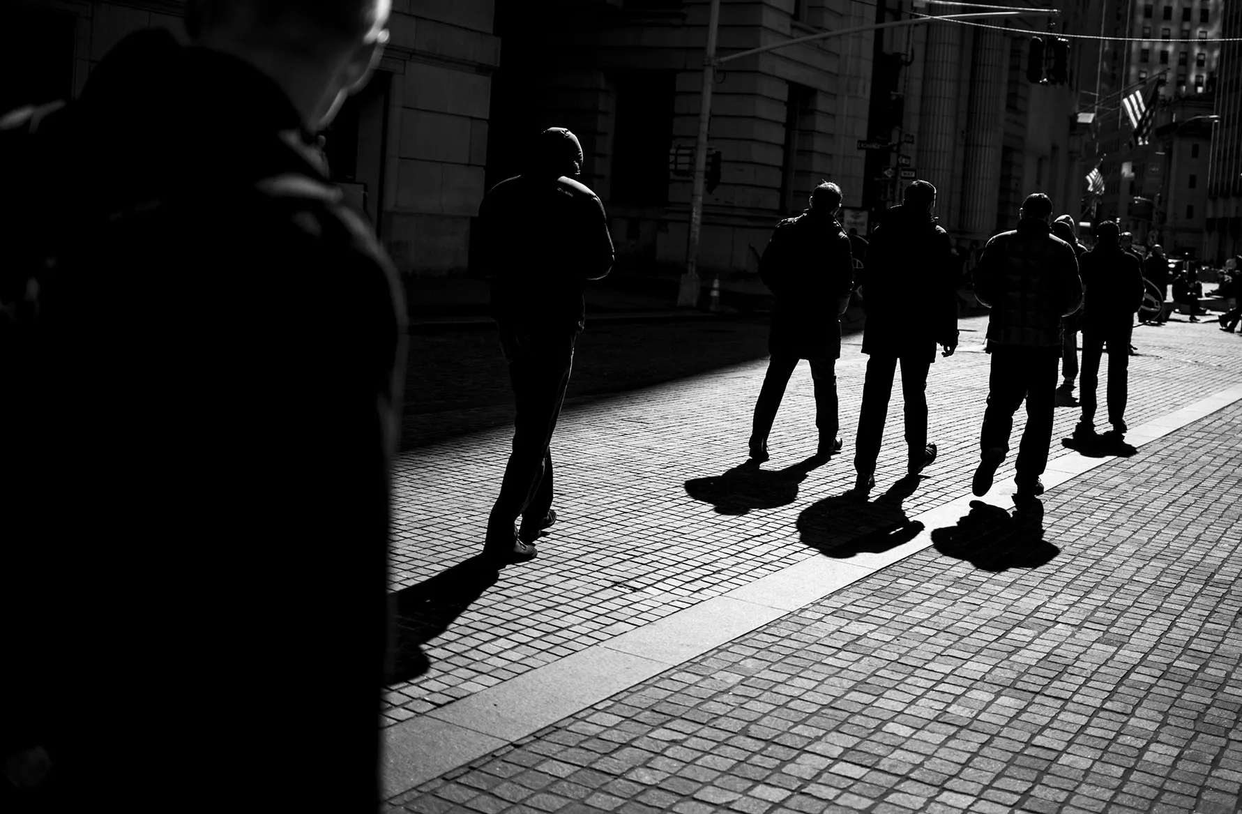 Pedestrians walk past the New York Stock Exchange.
