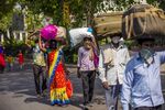 Migrant workers and their families carry their luggage during a partial lockdown imposed due to the coronavirus in New Delhi on May 14.
