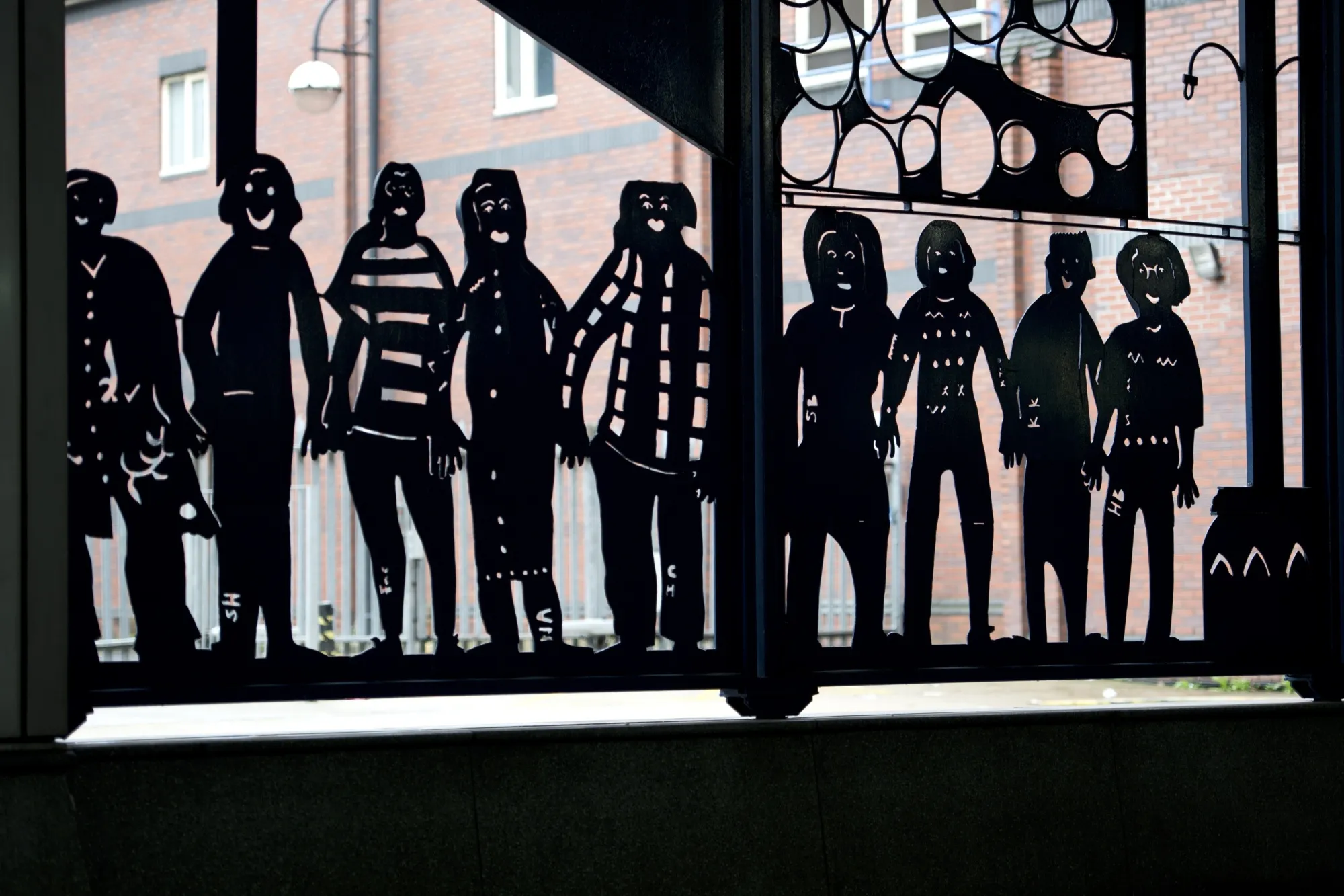 Metal artwork depicting silhouettes of people at the main bus station in Rotherham, UK.