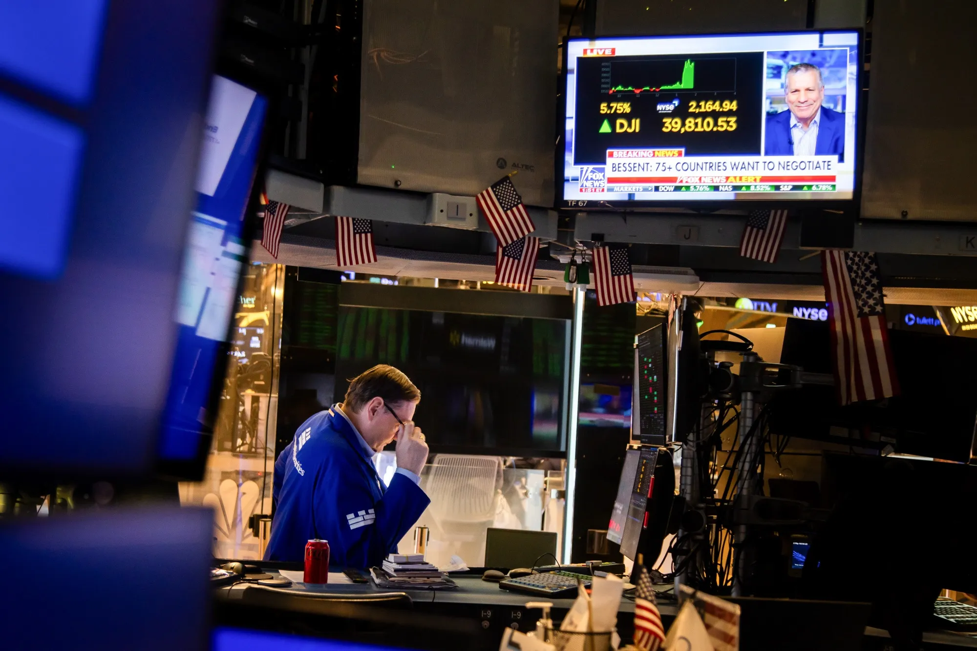 A television broadcasts market news as a trader works on the floor of the New York Stock Exchange (NYSE) on&nbsp;April 9