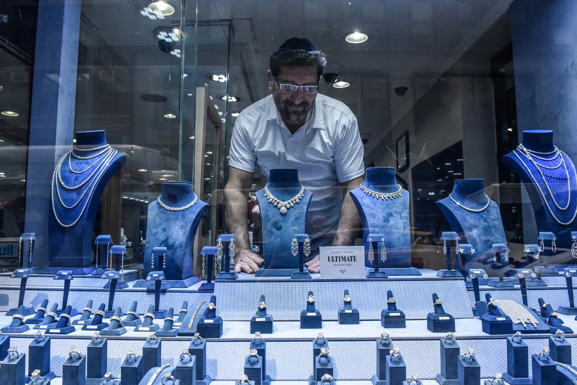 An employee adjusts diamond jewelry in the window of a store in New York.&nbsp;