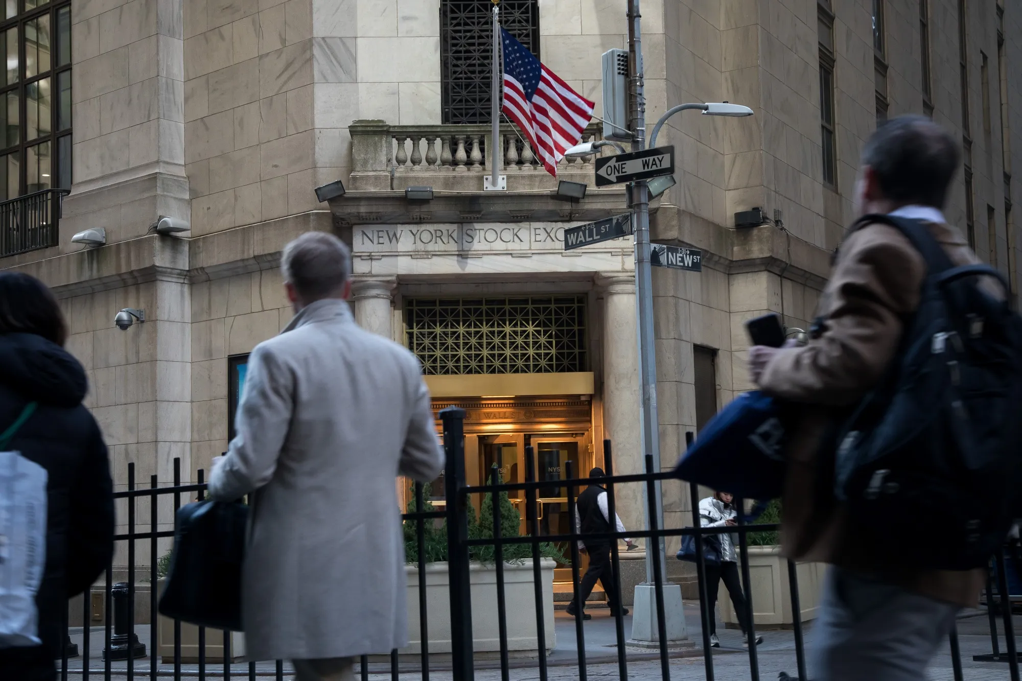 Pedestrians pass in front of the New York Stock Exchange (NYSE) in New York.
