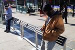 People use leaning bars at a bus stop in Brooklyn in 2016.