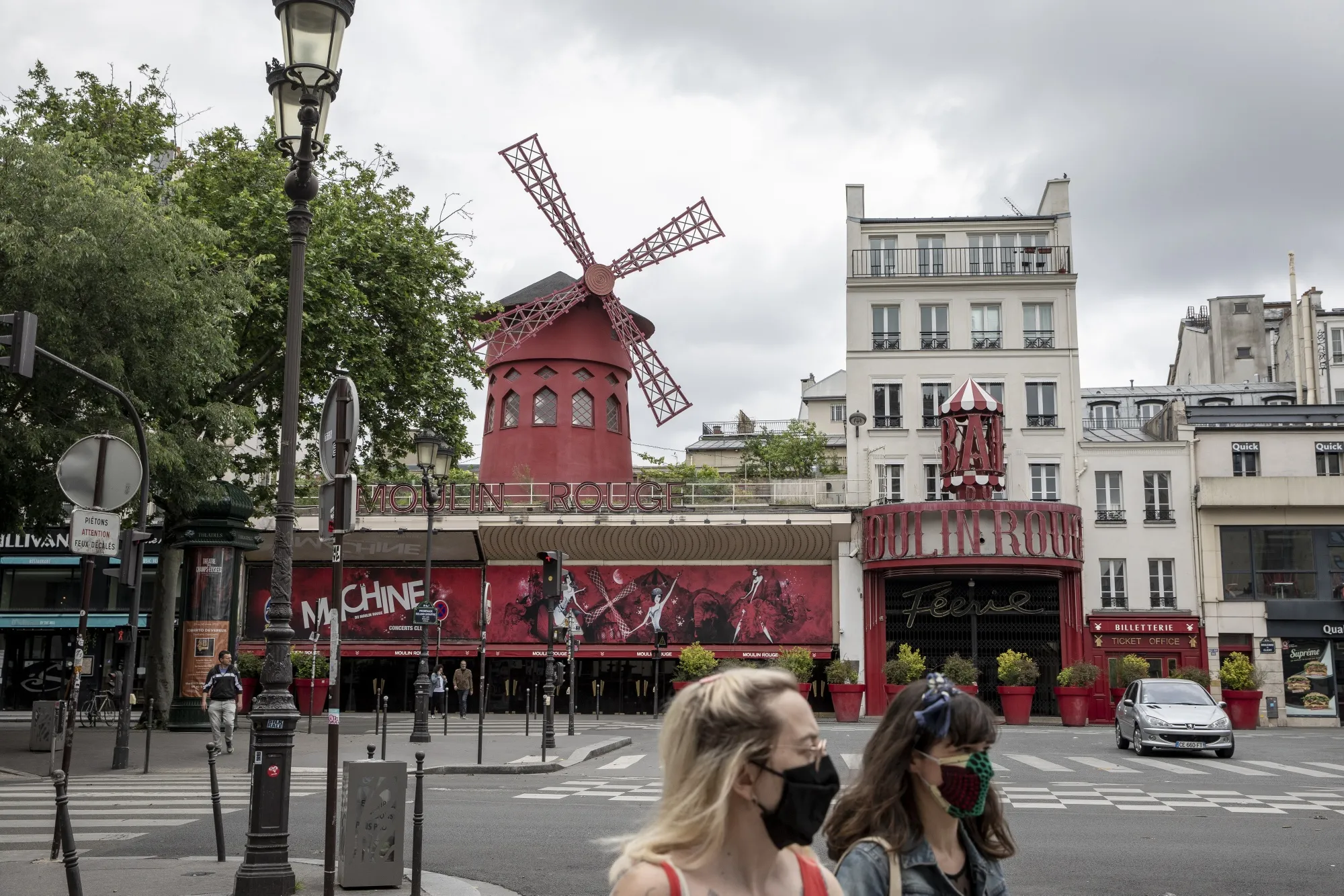 Pedestrians pass the closed Moulin Rouge theatre in Paris, on May 10.