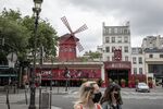 Pedestrians pass the closed Moulin Rouge theatre in Paris, on May 10.
