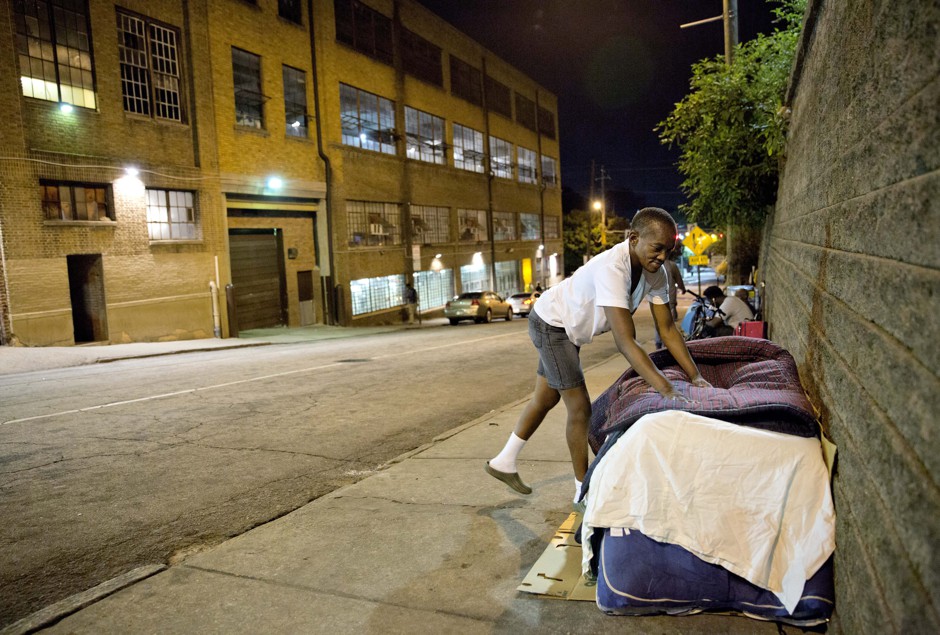 Wanda Walker prepares a bed across the street from the Metro Task Force for the Homeless shelter in downtown Atlanta, pictured in October 2014.