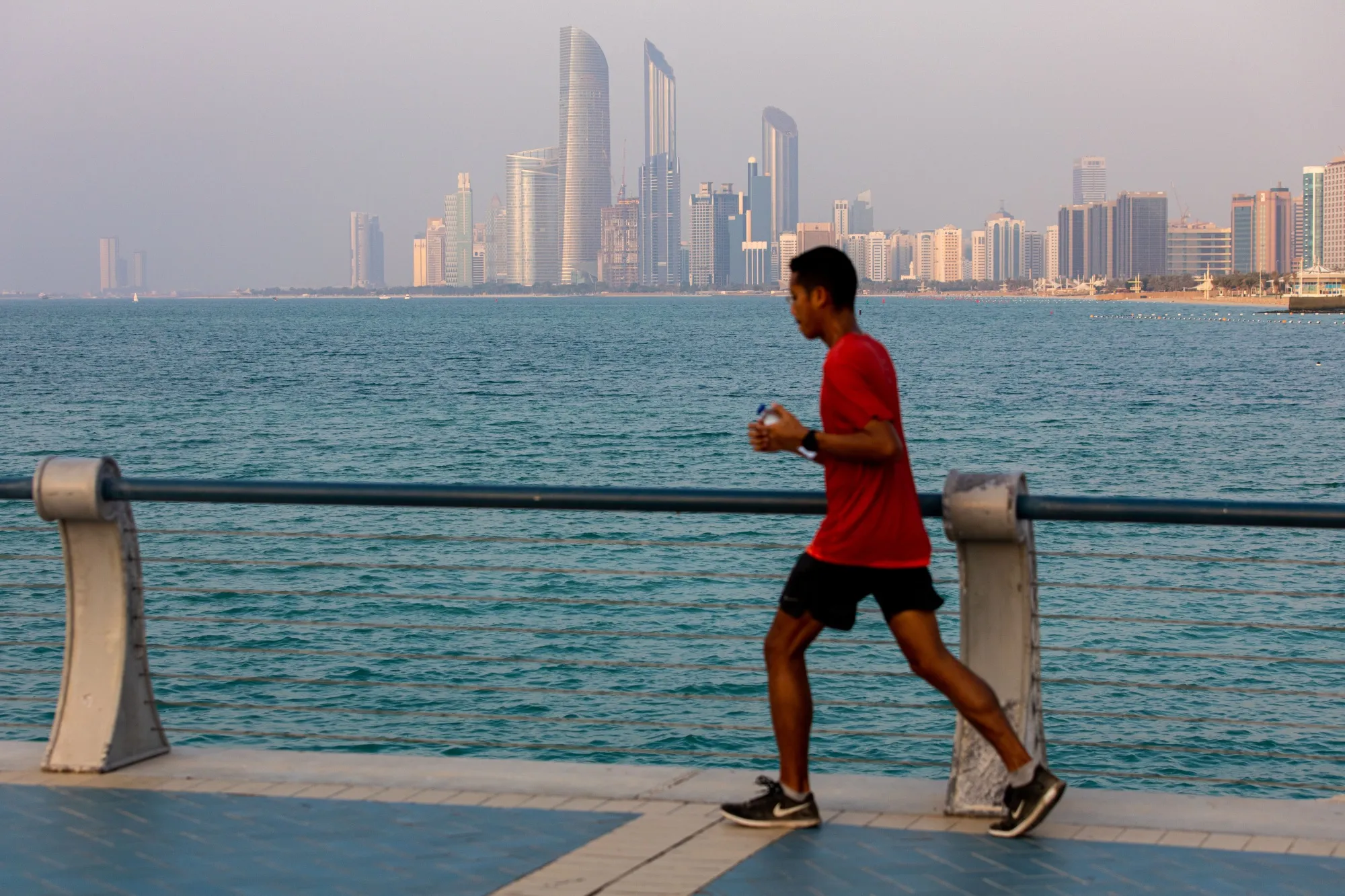 A man jogs along the waterside on the corniche in Abu Dhabi, United Arab Emirates.