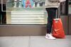 A shopper stands next to a Nike Inc. retail bag on the sidewalk in the SoHo neighborhood of New York, U.S., on Friday, Feb. 9, 2018. Bloomberg is scheduled to release consumer comfort figures on February 15.