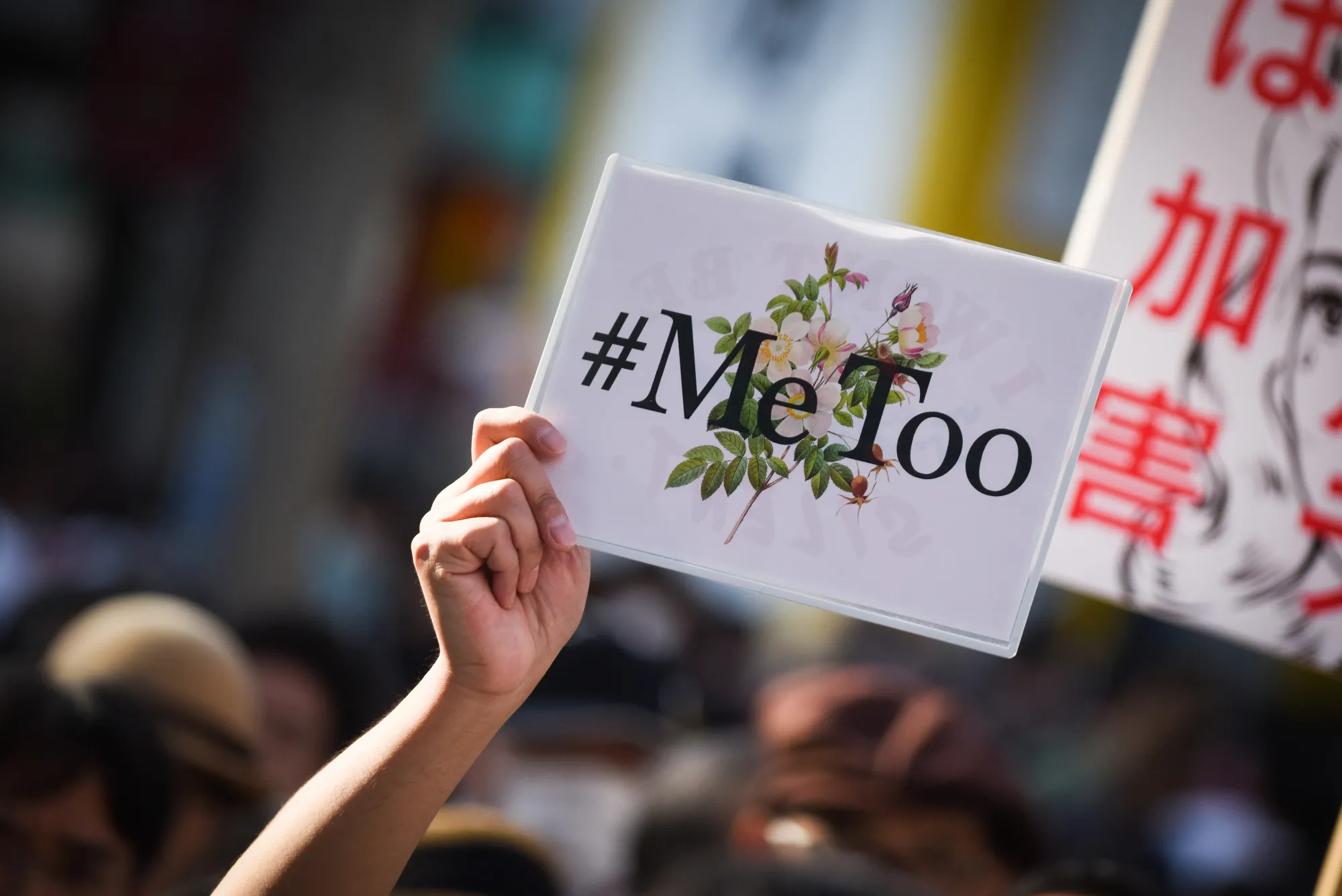 A demonstrator holds a sign reading "#Me Too" during a rally against sexual harassment in Shinjuku.