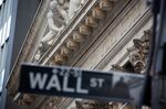 A Wall Street street sign in front of the New York Stock Exchange.