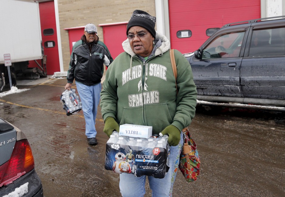 Flint resident Ruby Adolph carries bottled water and a replacement water filter.