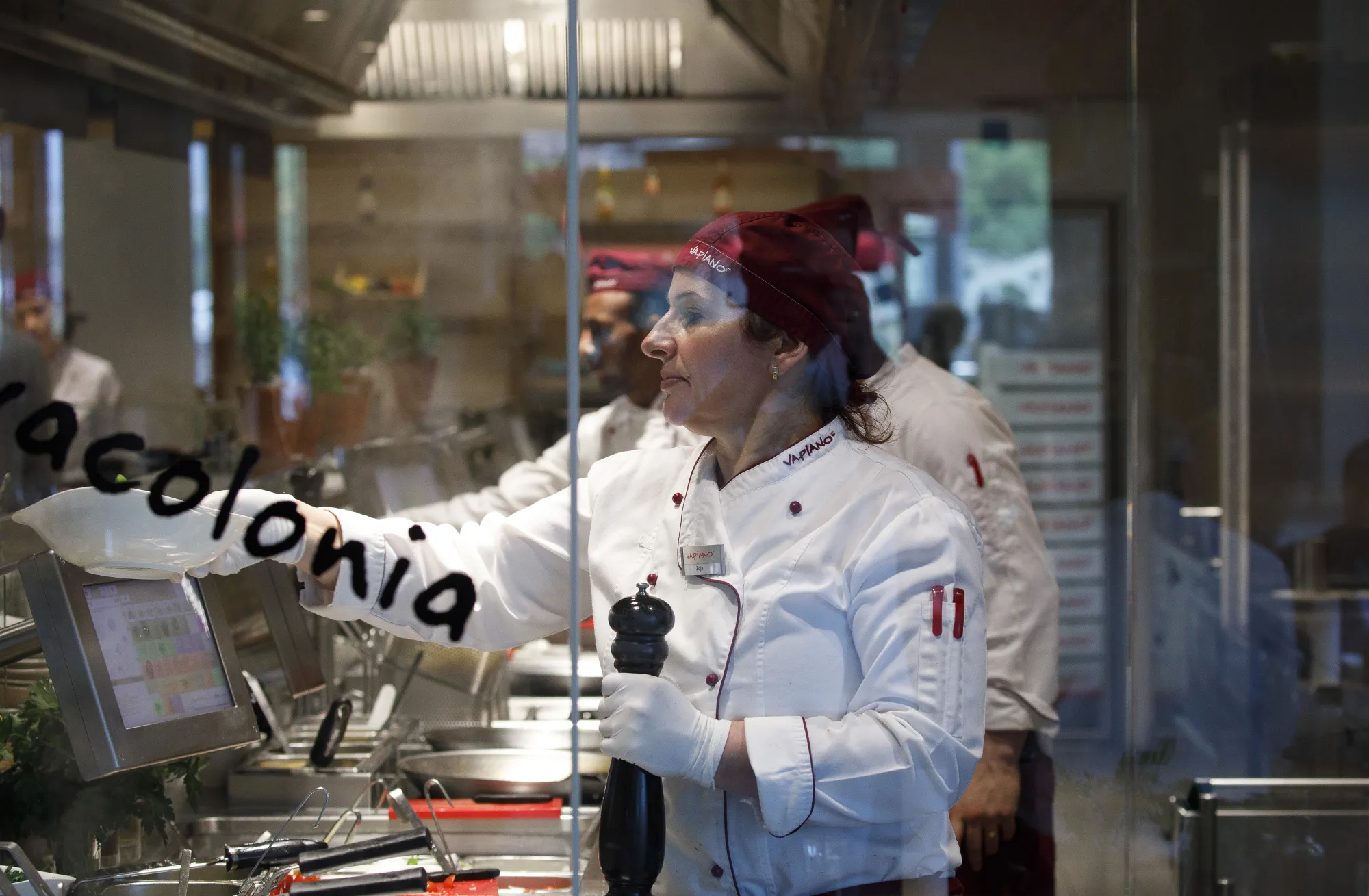 Employees prepare dishes for customers inside a Vapiano restaurant in Cologne, Germany, on May 14, 2018.&nbsp;