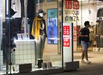 A shopper exits a Uniqlo store, operated by Fast Retailing Co., at night in the Ginza district of Tokyo.