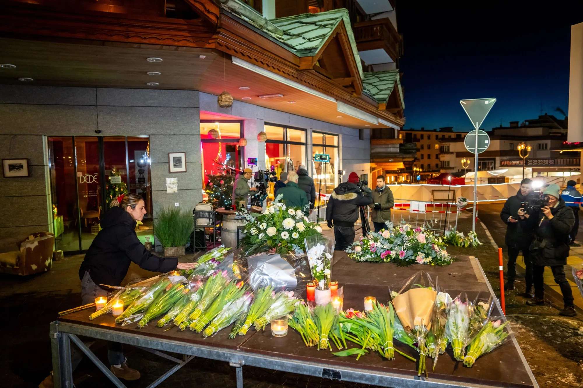 A woman lays flowers near the site where a&nbsp;fire&nbsp;broke out in a bar in the ski resort of Crans-Montana on Jan 1.&nbsp;